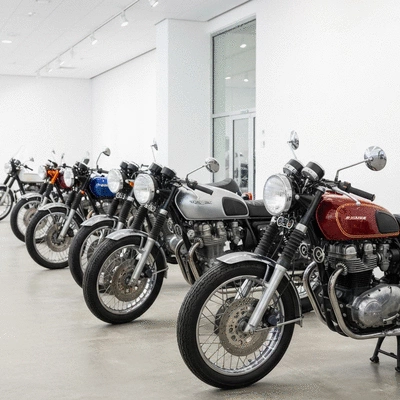 A row of perfectly restored vintage motorcycles in a bright showroom